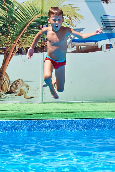 Garçon sautant dans la piscine de villégiature — Photo