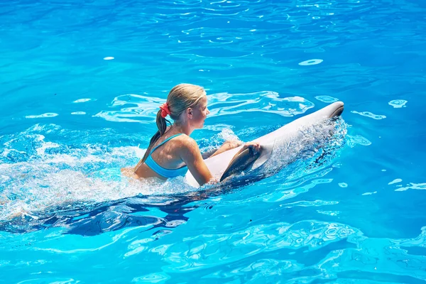 Mädchen schwimmt mit Delfin im Pool — Stockfoto