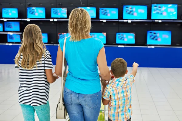 Mother with children in shop of tv — Stock Photo, Image