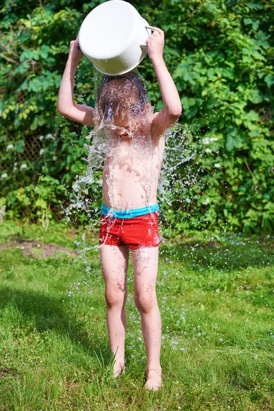 Lille gutt som helte vann over på sommeren – stockfoto