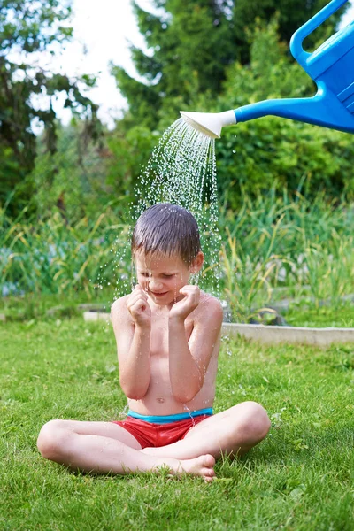 Menino derramando água de regar pode — Fotografia de Stock