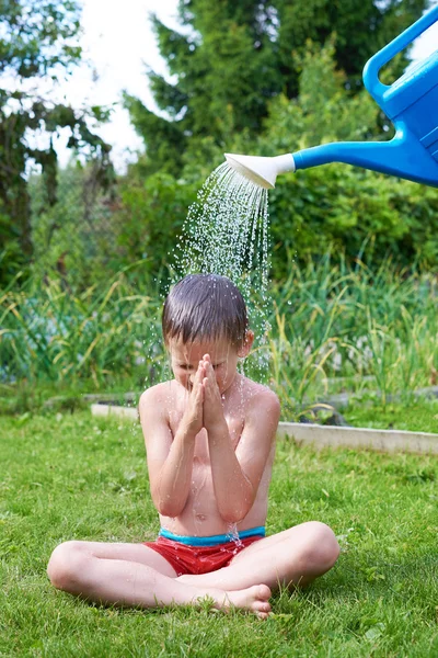Petit garçon versant de l'eau de l'arrosoir — Photo