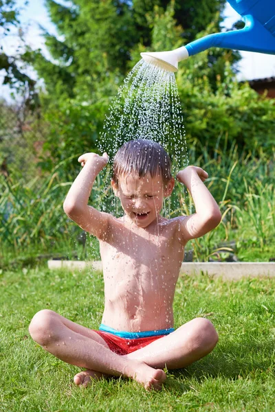 Kleiner Junge gießt Wasser aus Gießkanne — Stockfoto