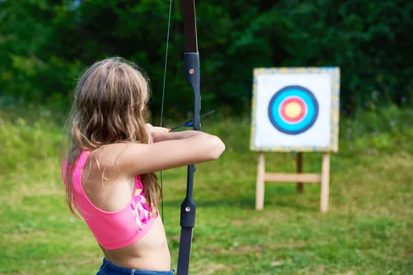 Ragazza adolescente con arco nock e mira a bersaglio — Foto Stock