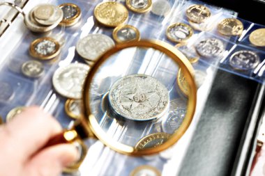 Collecting coins numismatics. Album with magnifying glass clipart