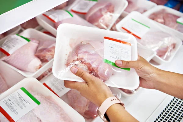 Human hands with turkey drumstick in the store