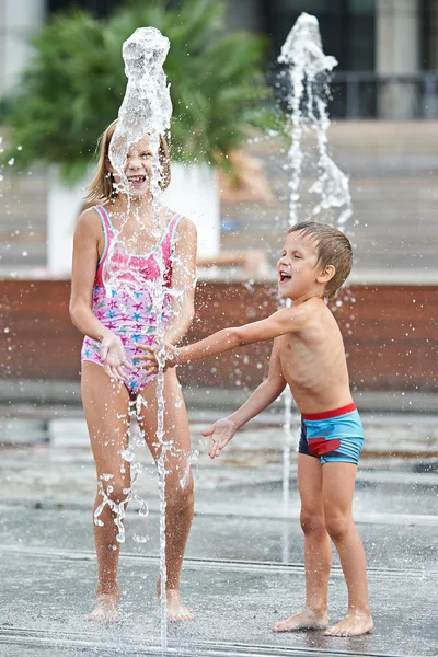 Счастливые дети играют в фонтане — стоковое фото