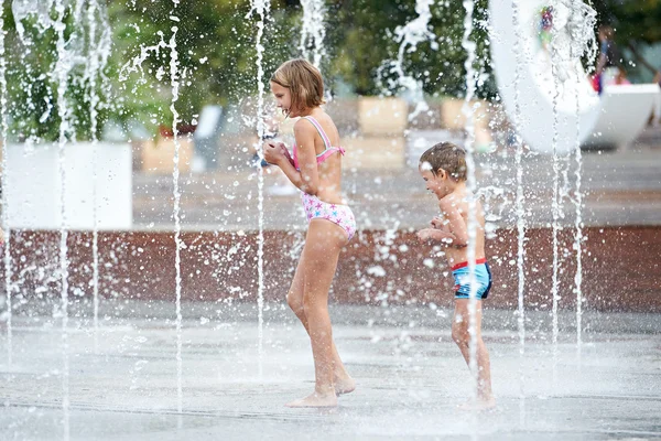 Enfants heureux jouant dans une fontaine — Photo