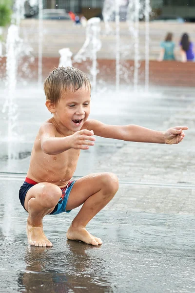 Enfant heureux jouant dans une fontaine — Photo