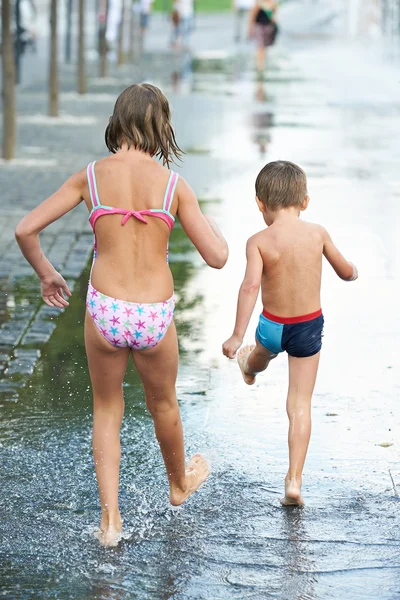 Enfants marchant dans une flaque d'eau — Photo