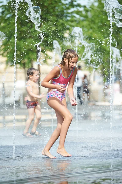 Menina brincando em uma fonte — Fotografia de Stock