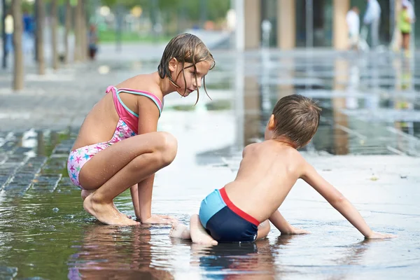 Children crawling in a puddle — Stock Photo, Image