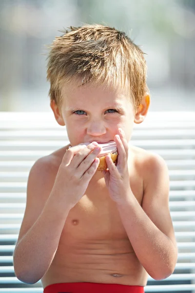 Piccolo ragazzo mangiare un panino — Foto Stock