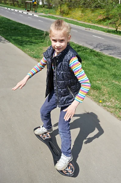 Ragazza a cavallo di uno skateboard — Foto Stock