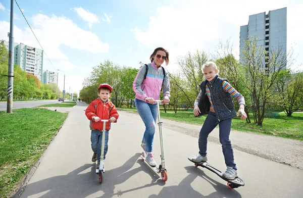 Rodina na koni skateboard a scooter — Stock fotografie