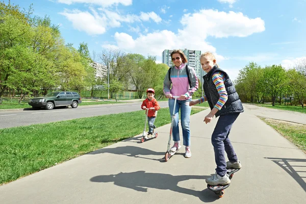 Familie fährt Skateboard und Roller — Stockfoto