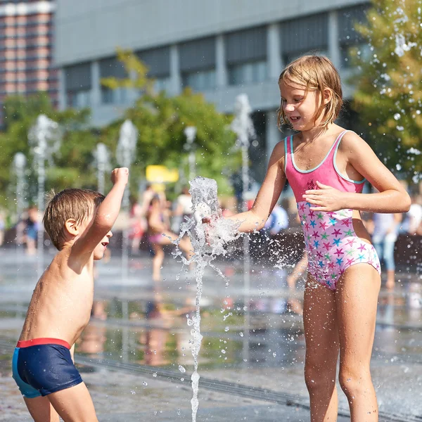 Счастливые дети играют в фонтане — стоковое фото