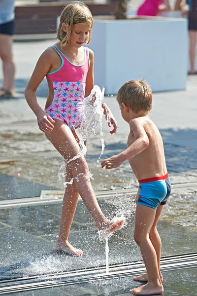 Crianças felizes brincando em uma fonte — Fotografia de Stock