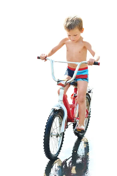 Mały chłopiec jeździ na rowerze na białym tle — Zdjęcie stockowe