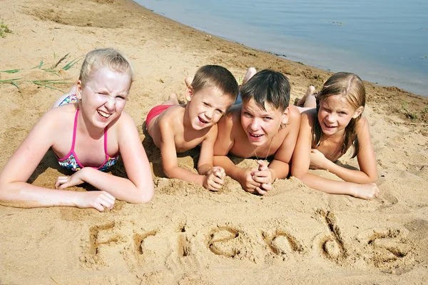 Children laying on the beach — Stock Photo, Image