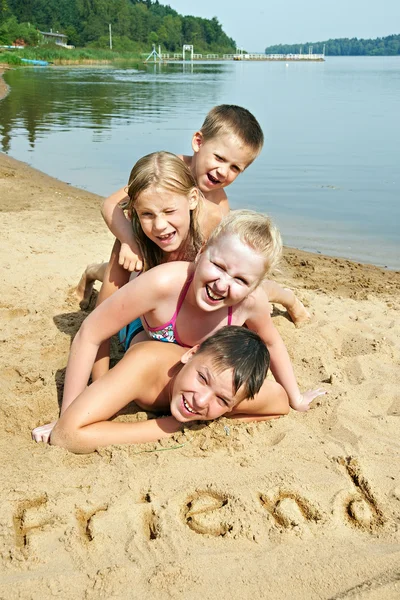 Children laying on the beach — Stock Photo, Image