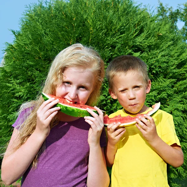 Gelukkig meisje en jongen eten van watermeloen — Stockfoto