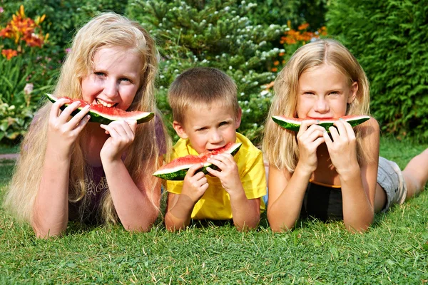 De gelukkige kinderen eten watermeloen — Stockfoto