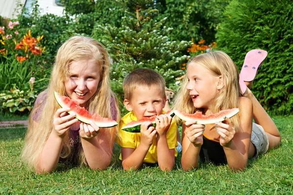 De gelukkige kinderen eten watermeloen — Stockfoto