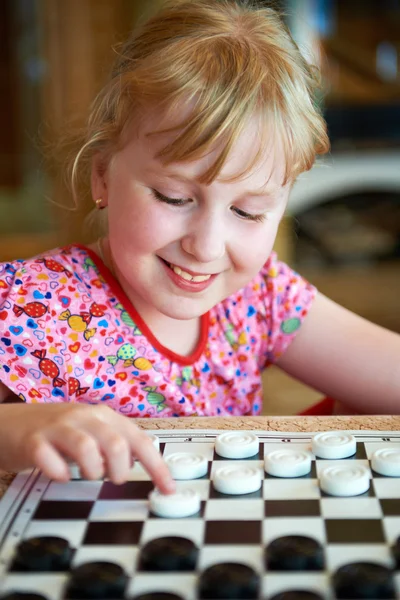 Little girl playing checkers — Stock Photo, Image