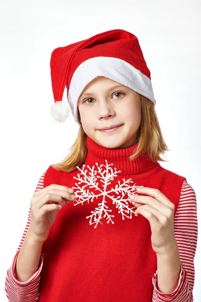 Schönes Mädchen mit rotem Weihnachtsmann-Hut mit Schneeflocke — Stockfoto