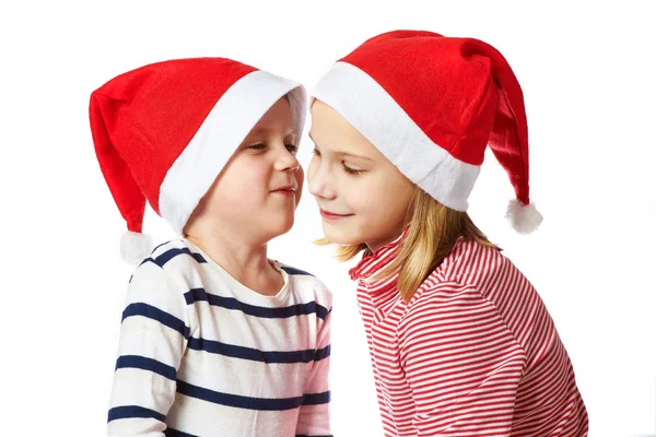 Mädchen und kleiner Junge mit Weihnachtsmann-Hut — Stockfoto