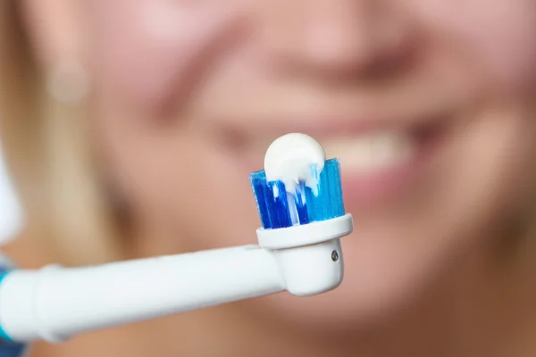 Γυναίκα βούρτσισμα ηλεκτρική οδοντόβουρτσα τα δόντια με οδοντόπαστα μακροεντολή — Φωτογραφία Αρχείου