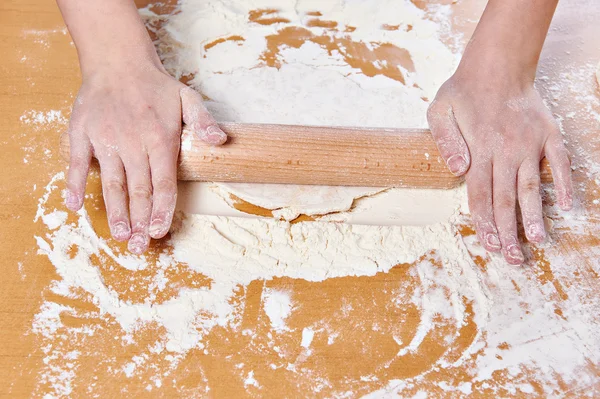 Девушка готовит тесто со скалкой на кухонном столе — стоковое фото