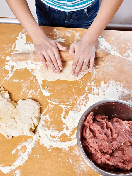 Dziewczyna przygotować ciasto z wałkiem na stole w kuchni — Zdjęcie stockowe