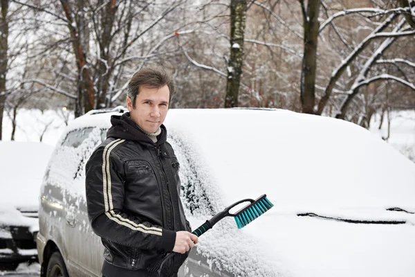 Bestuurder van de auto met penseel rond in sneeuw op winter — Stockfoto