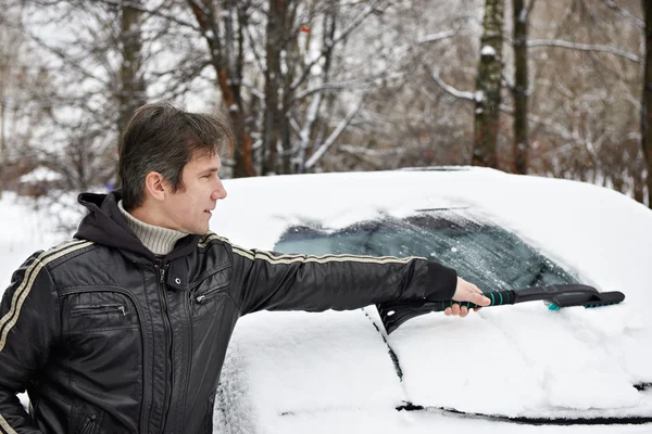 Chauffeur avec brosse nettoie la voiture de la neige — Photo