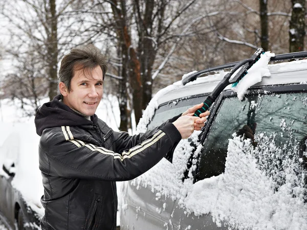 Driver with brush cleans car from snow — Stock Photo, Image