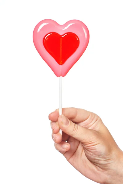 Hand som håller lollipop hjärta — Stockfoto