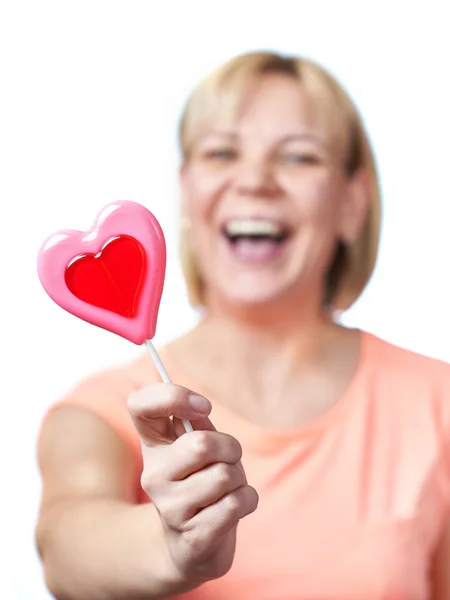 Happy girl with heart shaped lollipop — Stock Photo, Image