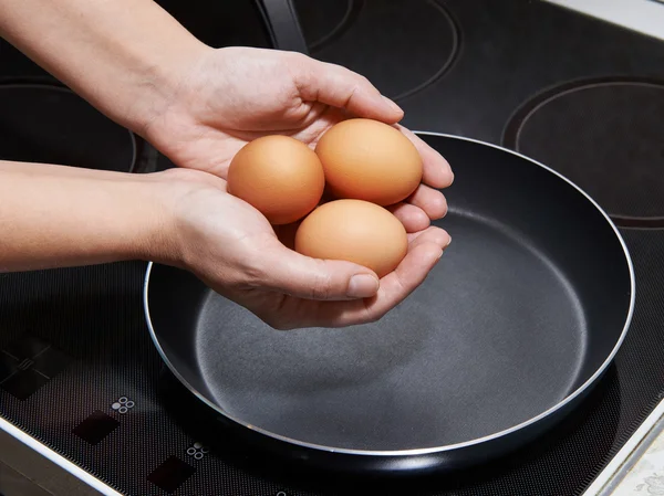 Mujer preparando huevos fritos — Foto de Stock