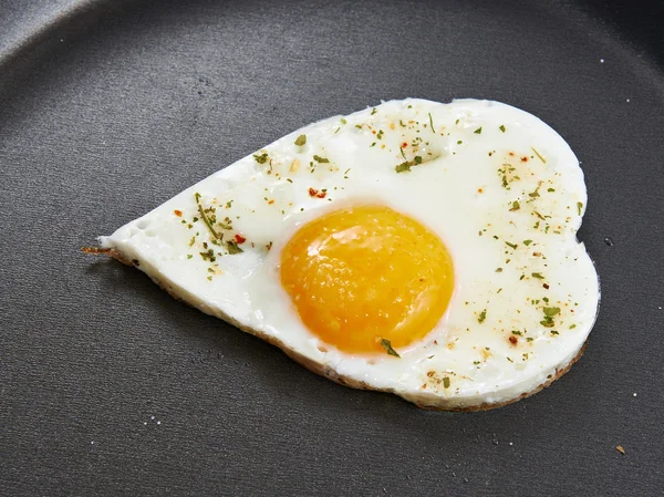 Жареные яйца в форме сердца — стоковое фото