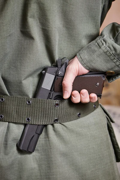 Soldado en uniforme sosteniendo pistola en su cinturón — Foto de Stock