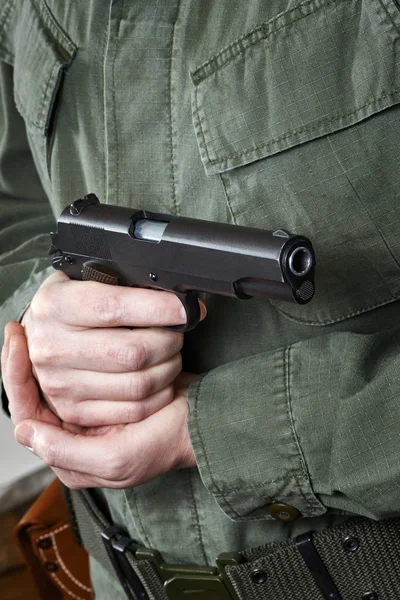 Soldier in uniform holding gun Colt — Stock Photo, Image