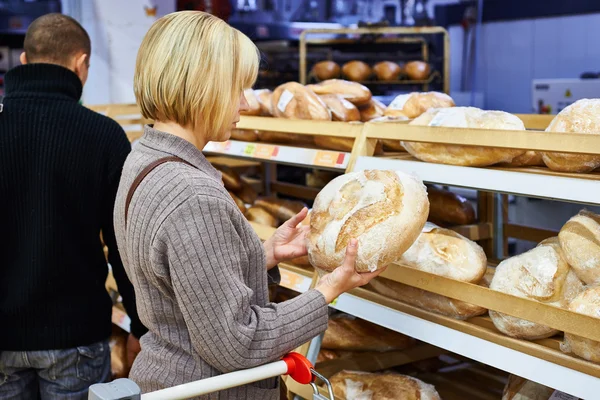 Молодая женщина выбирает хлеб — стоковое фото