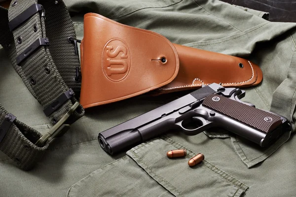 Colt gun pistol, holster and belt lie on military jacket — Stock Photo, Image