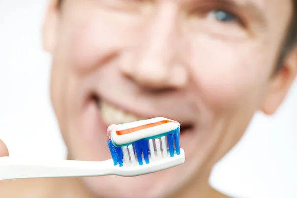 Man borstar tänder tandborste med tandkräm — Stockfoto