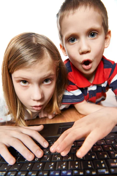 Дети удивляются и эмоционально смотрят на экран ноутбука — стоковое фото