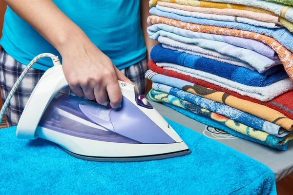 Vrouw huisvrouw strijken handdoeken — Stockfoto