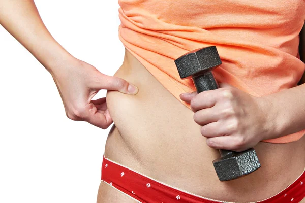 Woman with dumbbell showing fatty deposits on waist — Stock Photo, Image