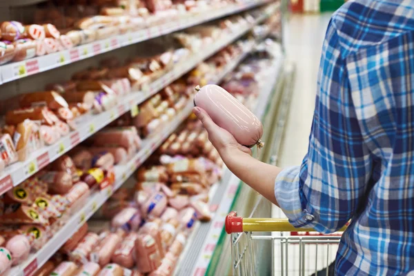 Woman buys boiled sausage in supermarket — Stock Photo, Image